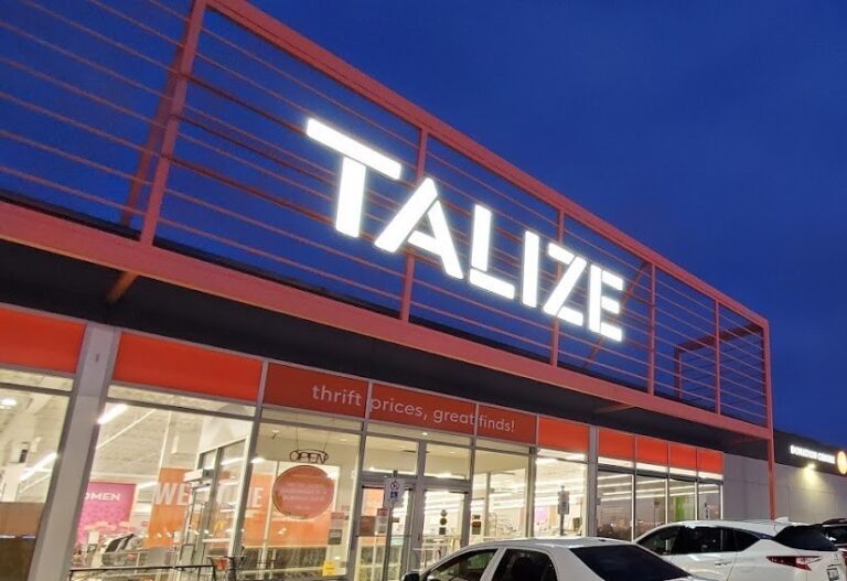 Talize's glowing storefront lettering pictured at night with a dark blue sky