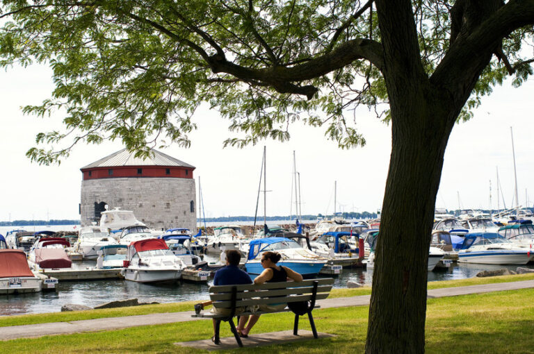 City-goers relaxing on a park bench in Confederation Basin Park