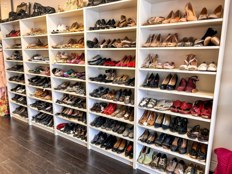 rows and rows of fancy shoes of many styles arranged on a wall of shelves inside the store