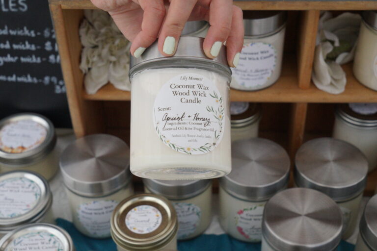 a close-up shot of a honey and apricot scented coconut candle with many other scent varieties arranged in the background