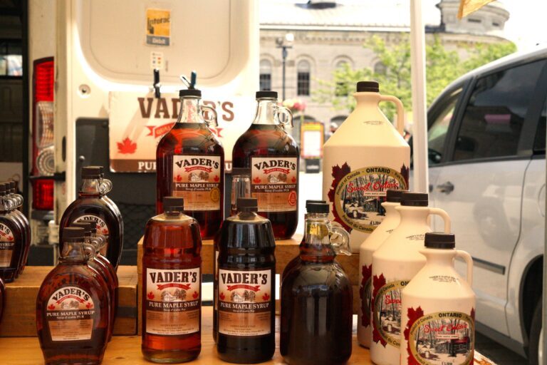 Vader's maple stall stands full of glimmering glass bottles of rich golden maple syrup 