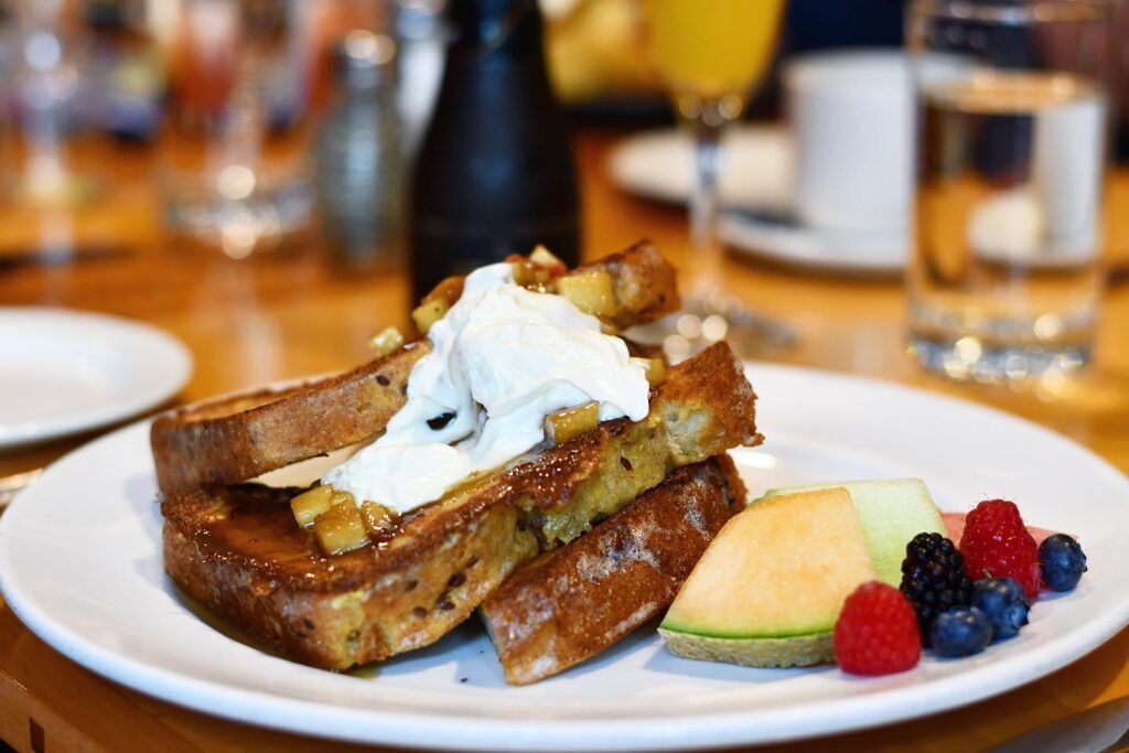 Chez Piggy's apple cider French toast is the ultimate fall dish, topped with caramelized apples, Calavados, caramel crème fraïche, salted caramel, and fresh fruit.