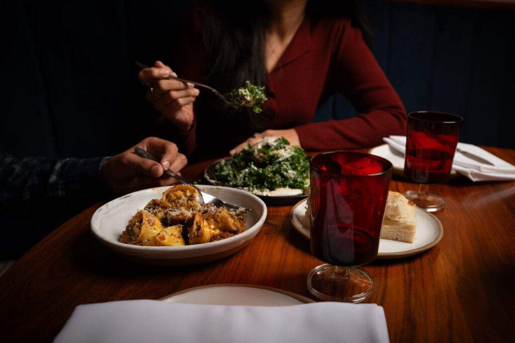 Two people eating prix fixe menu items at The Everly